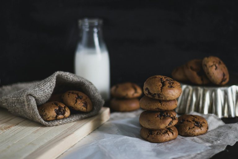Rustic setup of homemade chocolate cookies with a bottle of milk.